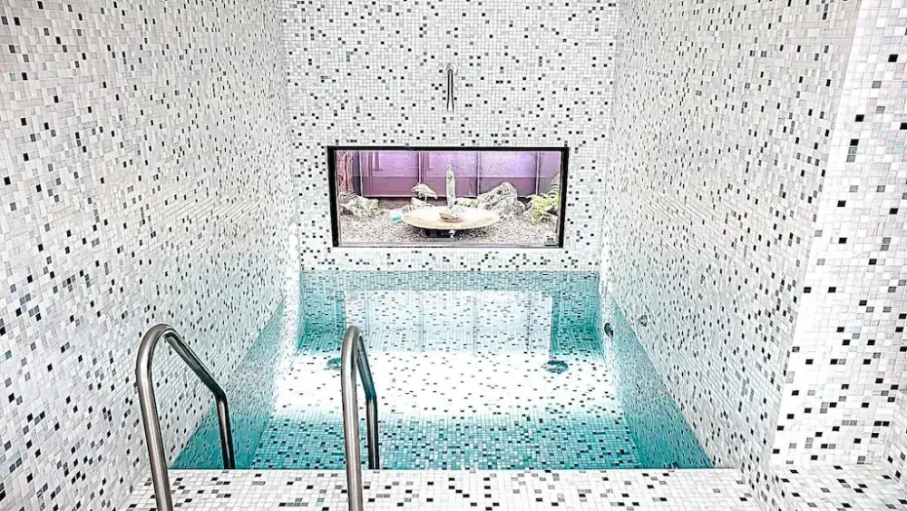Glass mosaic plunge pool with floor-to-ceiling mosaic surfaces.