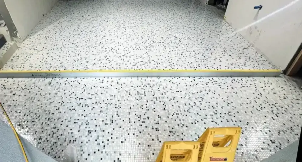 Levelled mosaic floor tile installation demonstrating surface accuracy.