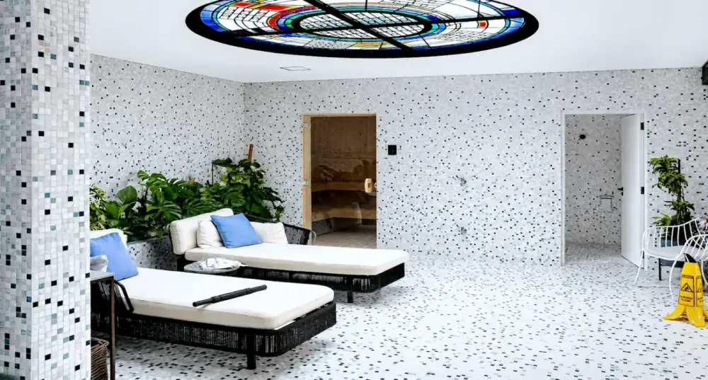 Precision mosaic Bisazza tile layout installation within bathhouse environment.