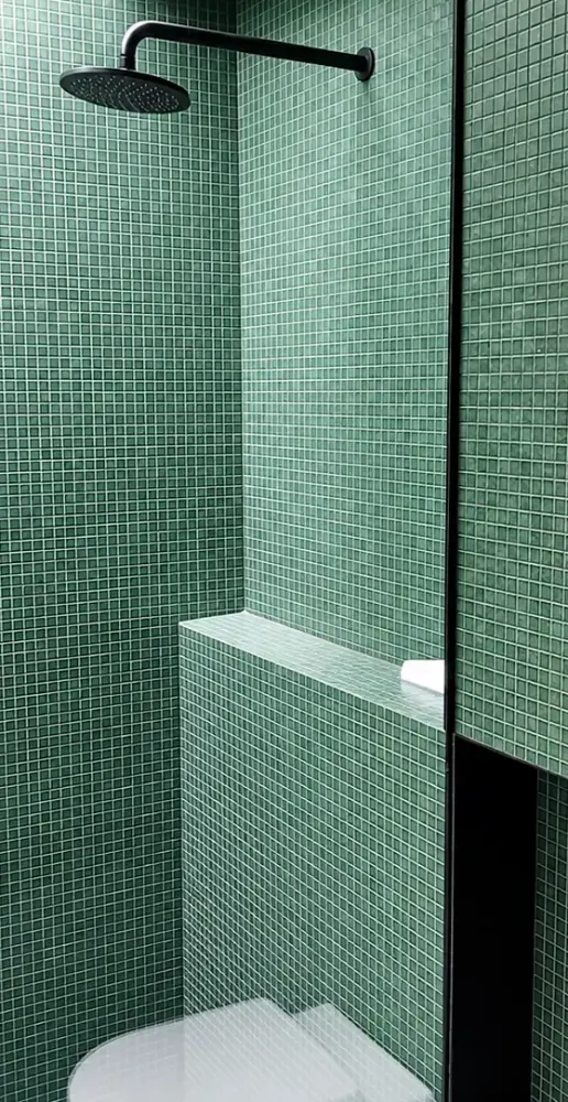 Glass mosaic shower wall showing precise surface preparation