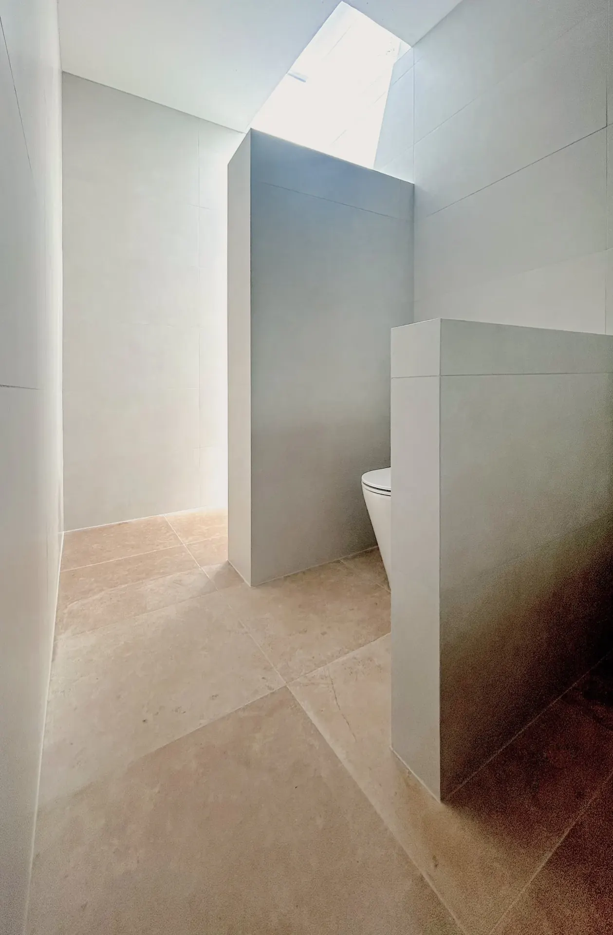 Large-format tiled bathroom privacy walls with crisp mitred outside corners