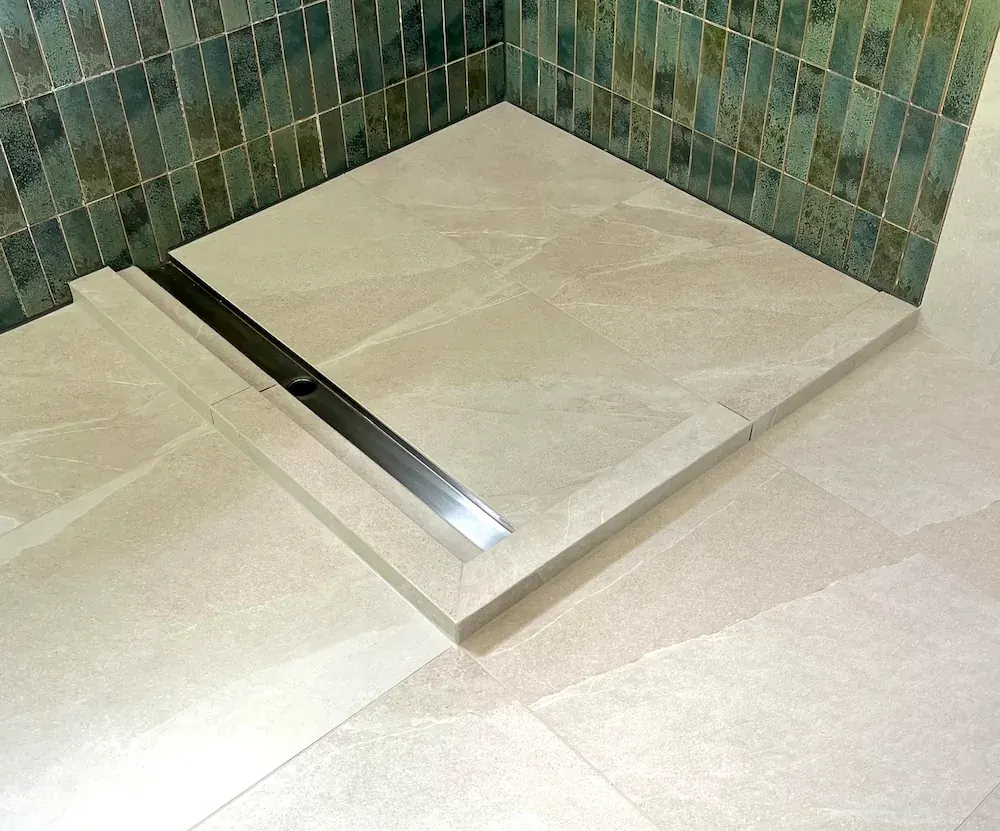 Raised porcelain shower tray with mitred perimeter and linear drain