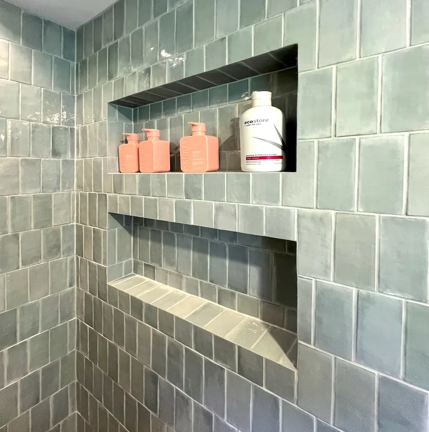 Two recessed shower niches with mitred glazed ceramic tile edges