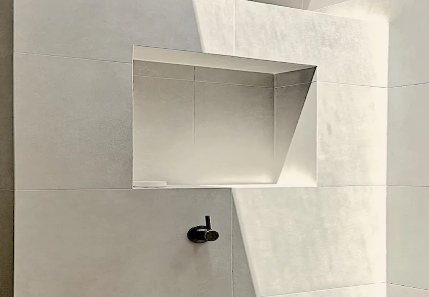 Projecting box niche with mitred porcelain edges and a sharp shadow line