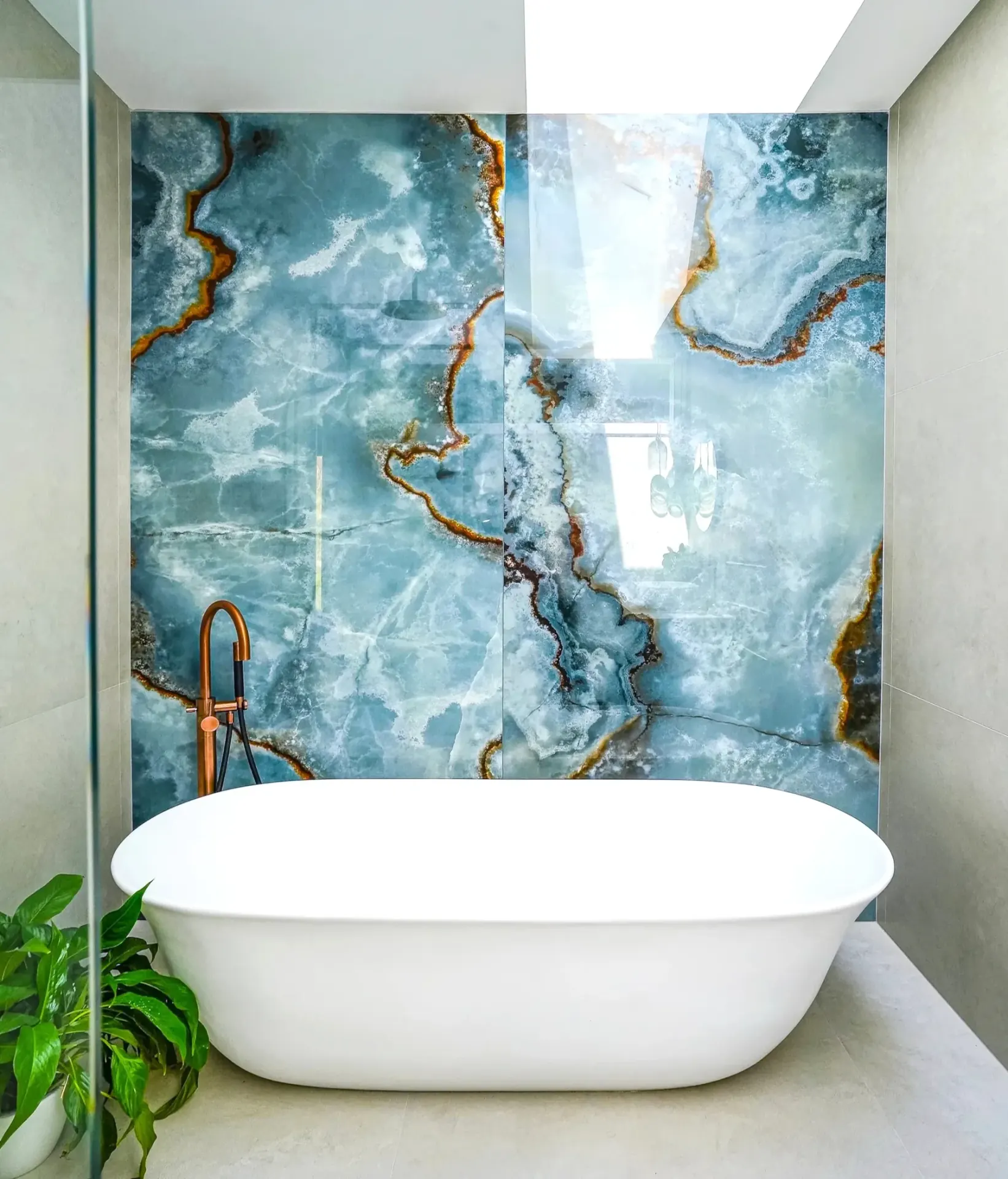 Large format onyx look porcelain slab bathroom feature wall installation