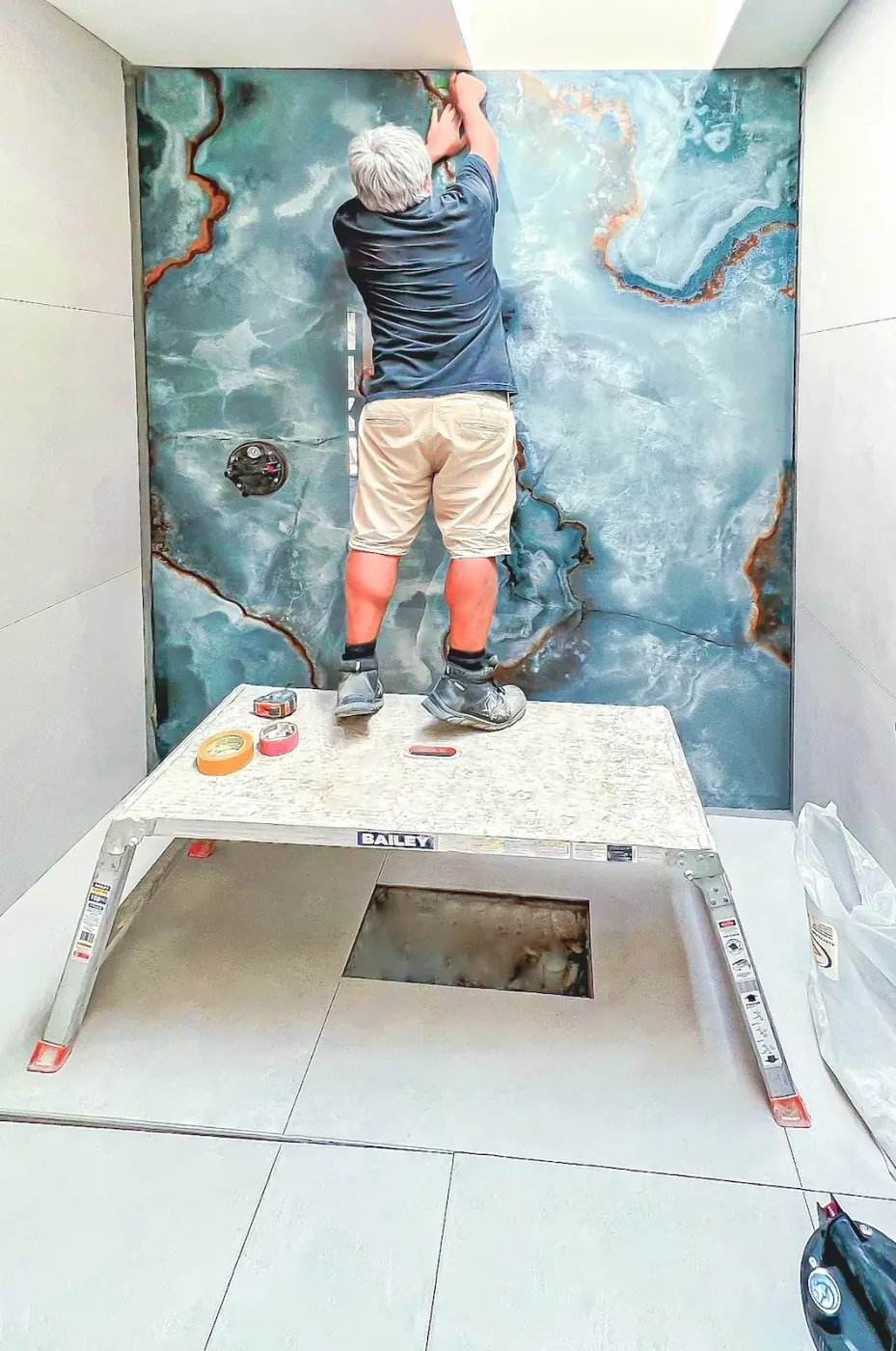 Large format stone look porcelain tile panel bathroom wall installation
