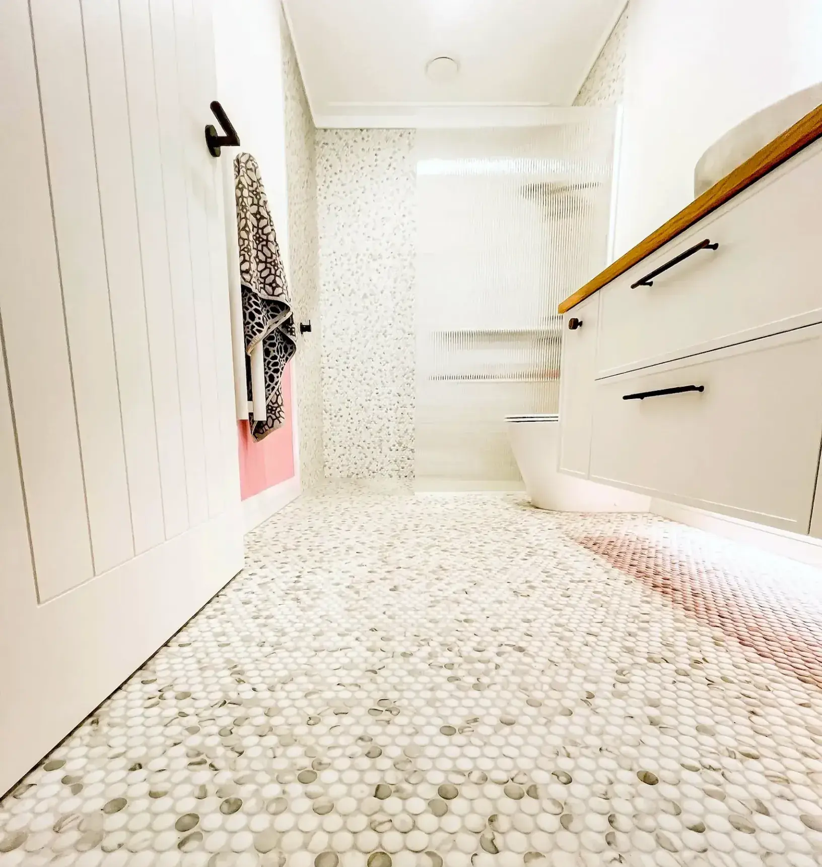 Marble-look penny round mosaic bathroom floor installation