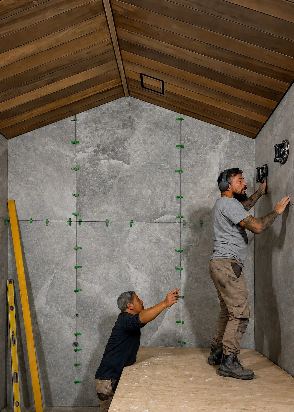 In progress large format porcelain slab installation with layout clips and precision checking