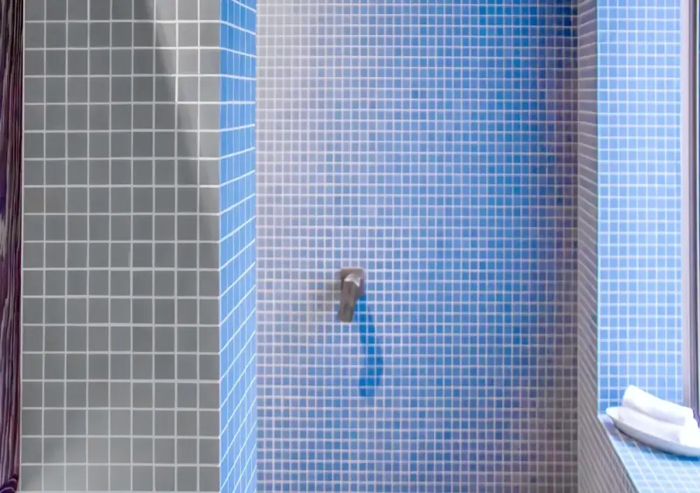 Curved mosaic tile installation around circular bathhouse opening.